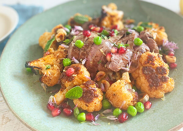 Gebratener Blumenkohlsalat mit Haselnüssen und Granatäpfeln, LammfleischSalat aus gebratenem Blumenkohl mit Haselnüssen und Granatapfel, rosa Lammfleisch