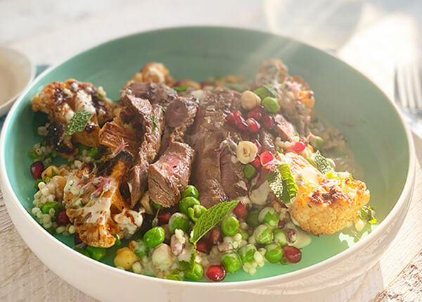 Roast cauliflower and pearl barley salad with hazelnuts and pomegranates, pink lamb