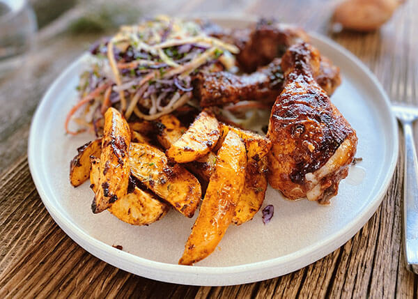 Hähnchenkeulen in Barbecue-Sauce, Krautsalat, KartoffelspaltenHähnchenkeulen in Barbecue-Soße, Herbst-Krautsalat, Kartoffelspalten