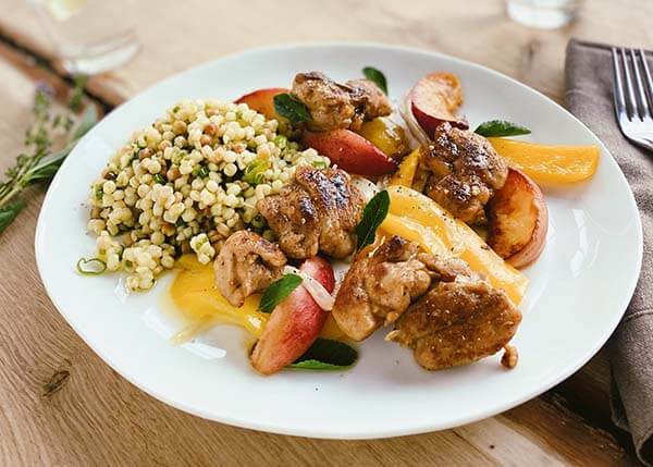Chicken casserole with peaches, peppers and almonds, herbaceous fregola