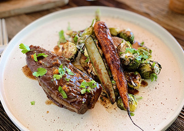 Slow-cooked veal shank with gremolata juice, roasted vegetables with citrus